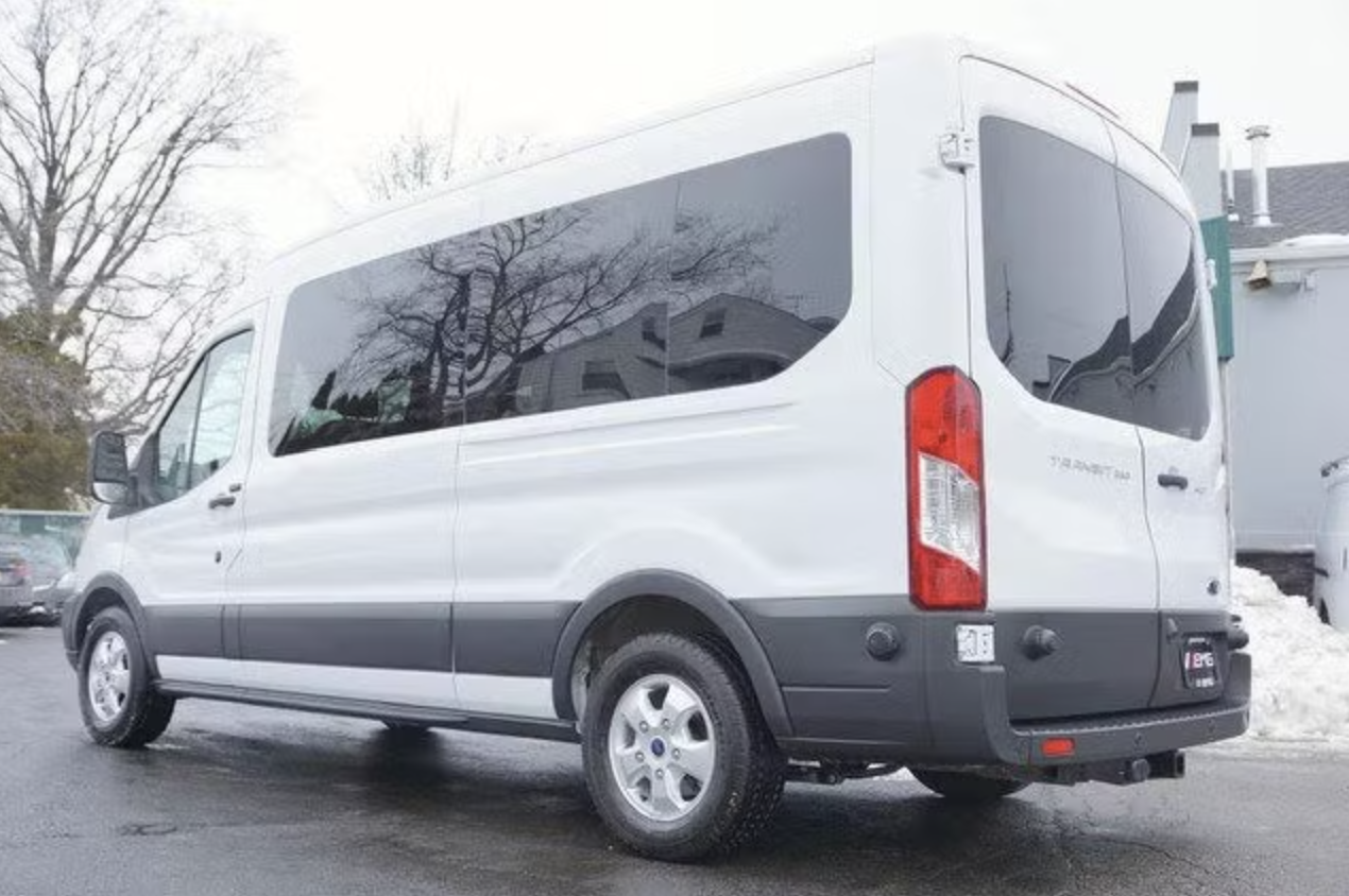 Rear three-quarter view of the white 2017 Ford Transit 350 15-passenger van